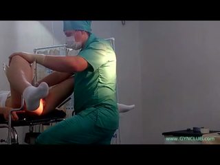 Um jovem jovem senhora em branca meias em um ginecologista cadeira