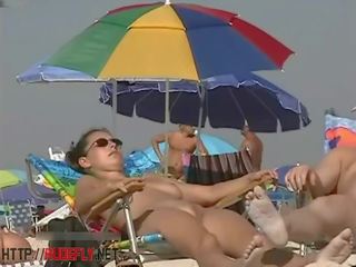 Sebuah dapper perempuan di sebuah telanjang pantai mata-mata kamera video
